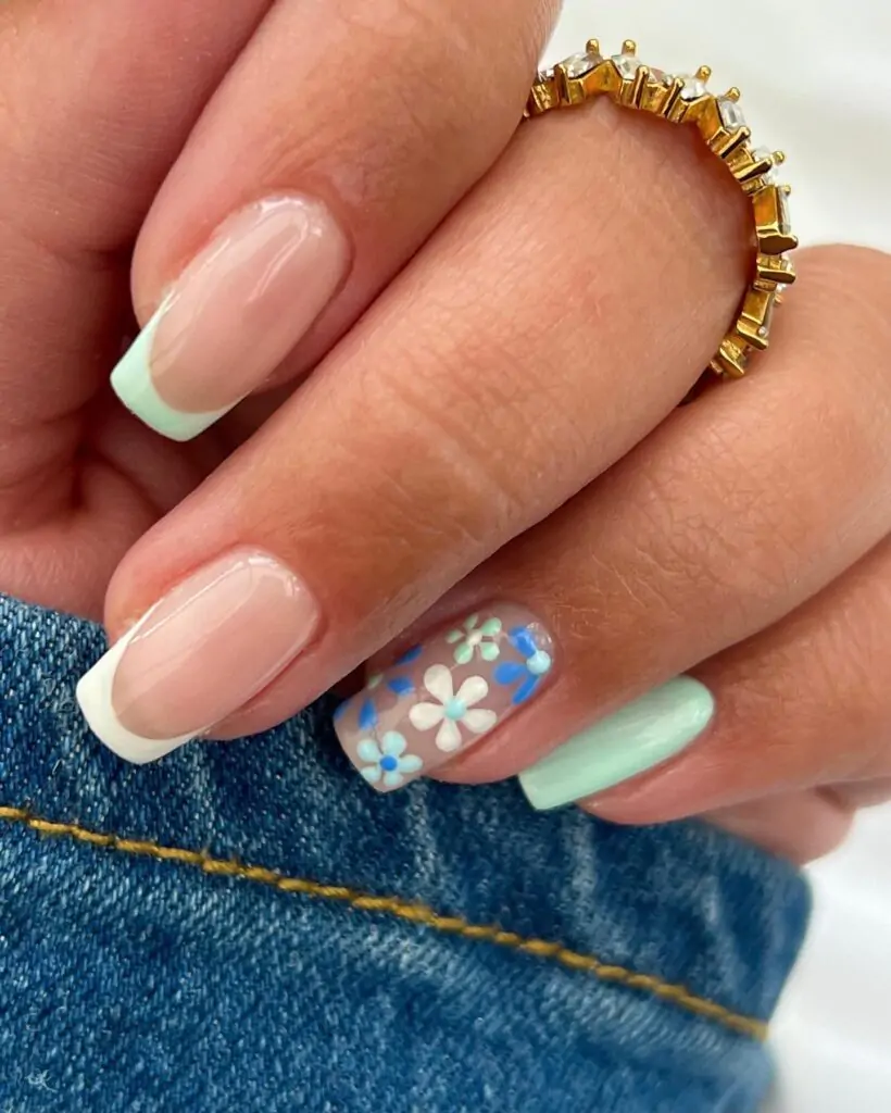 A spring manicure includes bright pastel shades and floral patterns, welcoming the freshness of the new season with pale pinks, whites, or greens and small flowers to symbolize the blooming nature outside.