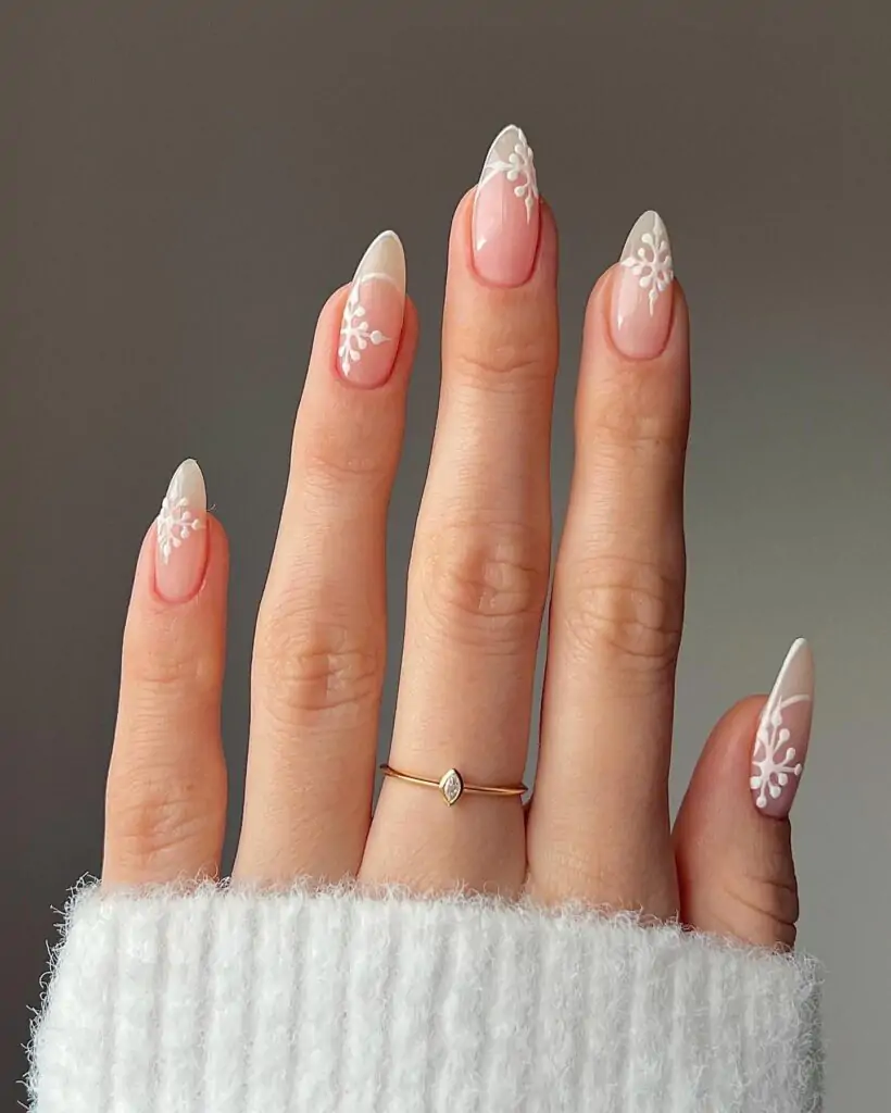 This is a French manicure with art. It has a pink base, white tips, and floral designs. The almond shape adds to its beauty, and it is perfect for an artistic appearance. Easy yet beautiful!