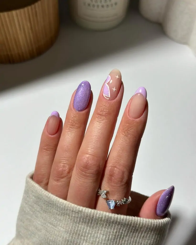 This look, "Glittery Night Sky," features sparkly purple glitter and nude hues, with a flower and star accent nail. It's a playful look that fuses glitter glamour and minimalist art, ideal for a night out!