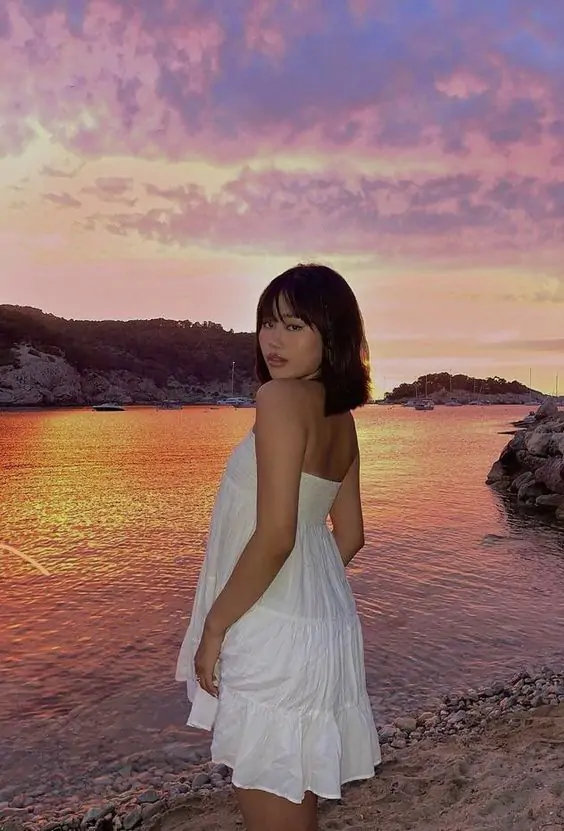 The outfit features a white sleeveless dress.

