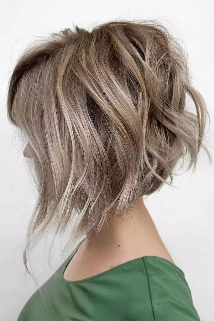 Inverted bob haircut with longer hair in the front and stacked layers in the back.