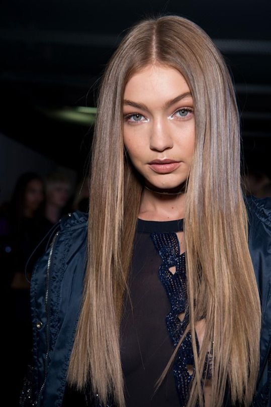 Woman with ultra-straight, long blonde hair and a slight side part.