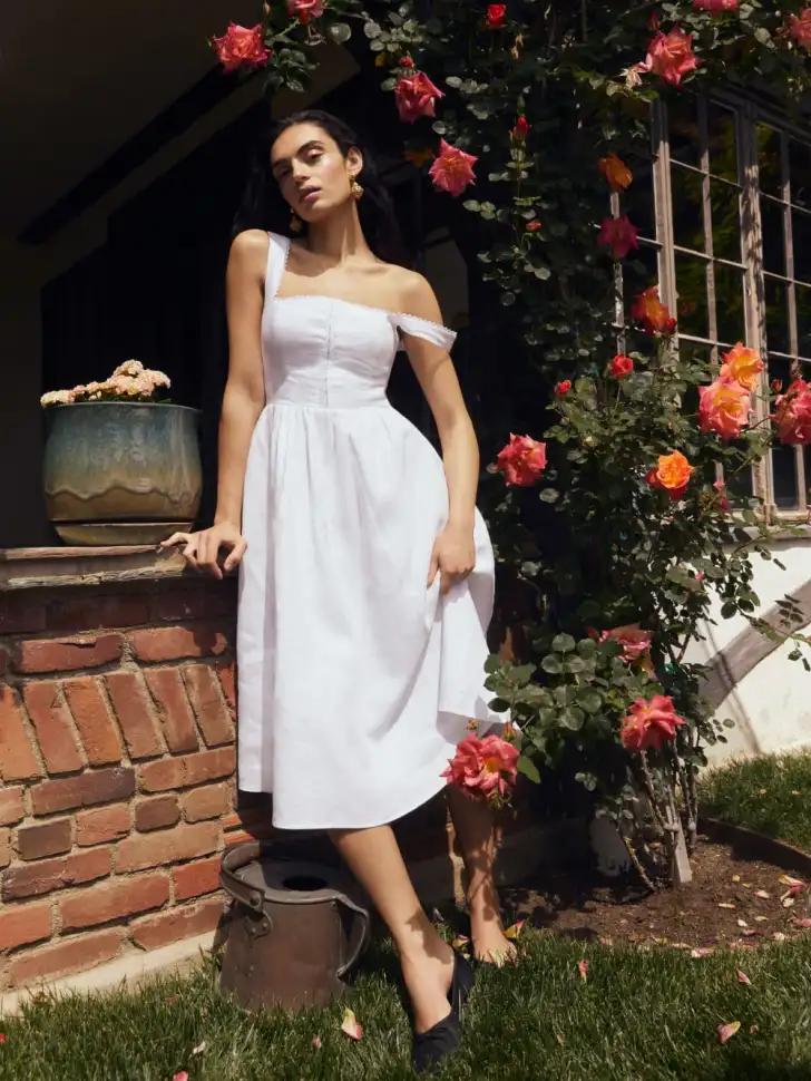 Woman Wearing a Breezy Off-Shoulder White Midi Dress with A-Line Silhouette in a Garden Setting.White Midi Dress, Off-Shoulder Dress, Summer Fashion 2024, Women's Dresses, Breezy Summer Outfits, Garden Party Dress