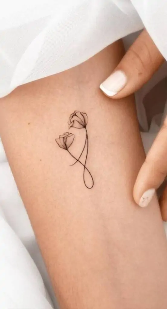 A delicate flower tattoo symbolizes beauty, growth, and nature. Whether it's a single bloom or a small bouquet, this design adds a touch of elegance to your skin. minimalist flower tattoo, simple floral tattoo designs, tiny flower tattoos