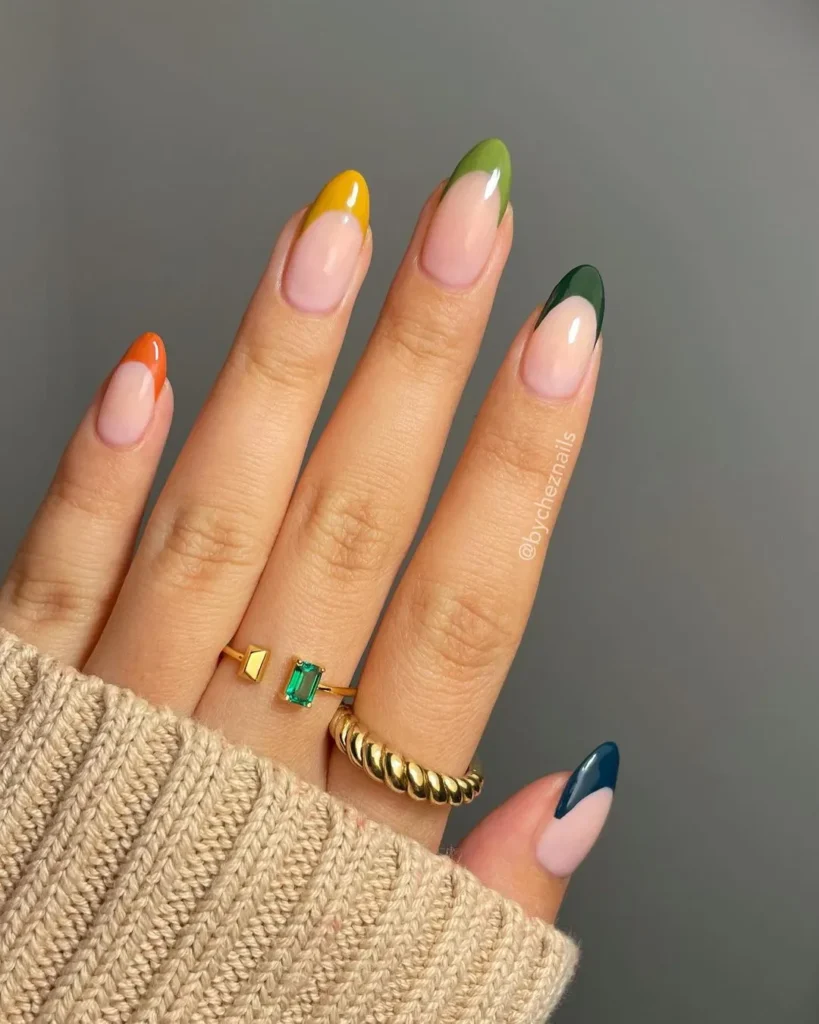 French manicure with colorful tips in green, yellow, orange, and navy, perfect for fall.