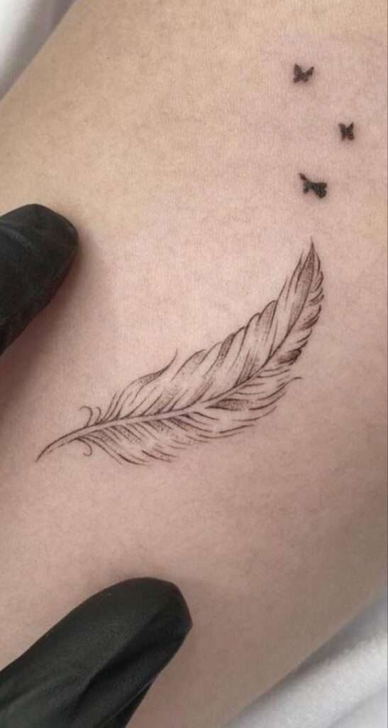 A feather tattoo is light, delicate, and often represents freedom, hope, or a connection to the spiritual world. It's a beautiful minimalist choice.minimalist feather tattoo, small feather tattoo designs, simple feather tattoos