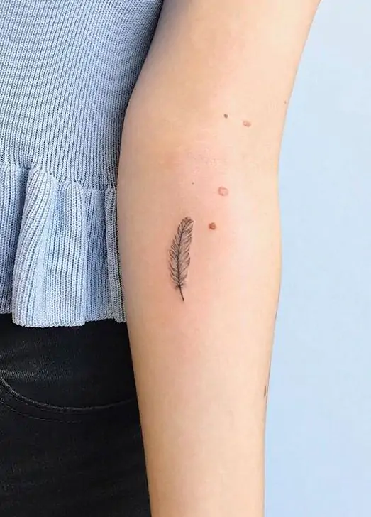A feather tattoo is light, delicate, and often represents freedom, hope, or a connection to the spiritual world. It's a beautiful minimalist choice.minimalist feather tattoo, small feather tattoo designs, simple feather tattoos