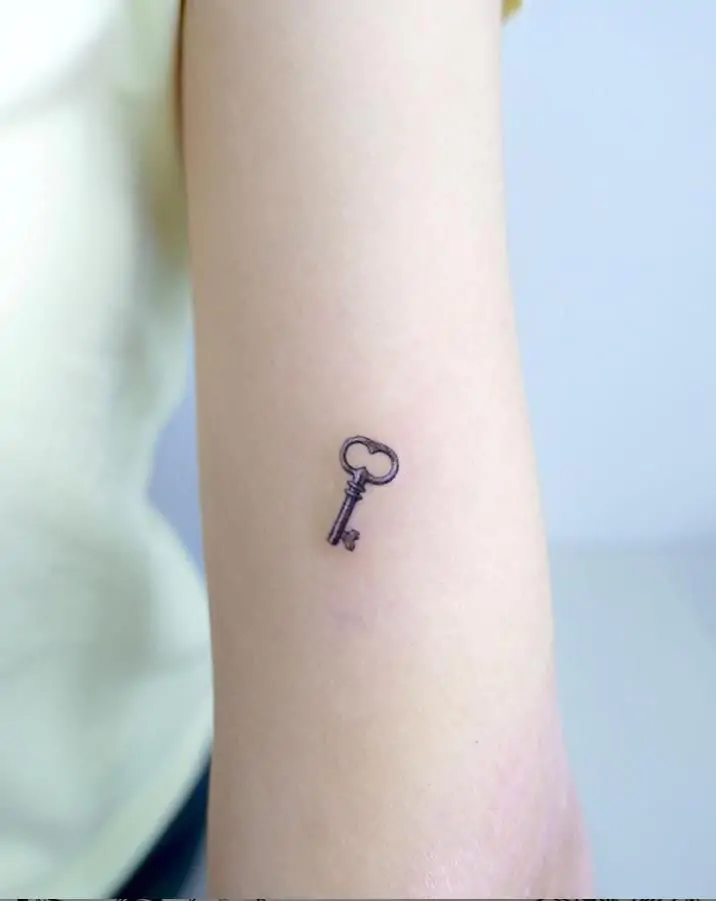 A small key tattoo symbolizes opportunity, secrets, or unlocking your potential. It's a unique and meaningful minimalist design. minimalist key tattoo, small key tattoo ideas, simple lock and key tattoos