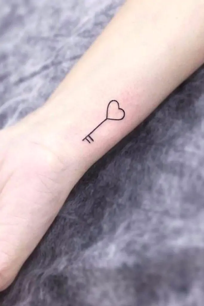 A small key tattoo symbolizes opportunity, secrets, or unlocking your potential. It's a unique and meaningful minimalist design. minimalist key tattoo, small key tattoo ideas, simple lock and key tattoos