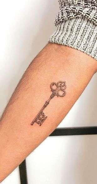 A small key tattoo symbolizes opportunity, secrets, or unlocking your potential. It's a unique and meaningful minimalist design. minimalist key tattoo, small key tattoo ideas, simple lock and key tattoos