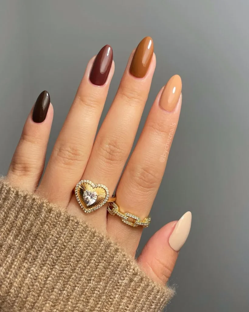 A fall-inspired mix and match nail design featuring chocolate, caramel, and nude tones.