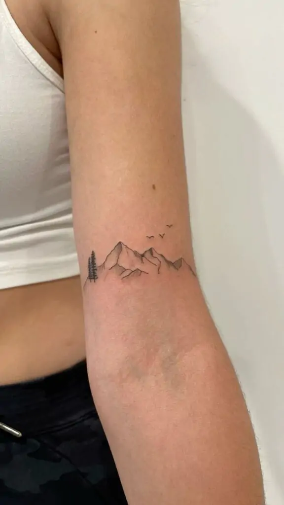 A minimalist mountain tattoo represents strength, adventure, and a love for nature. It's a great choice for those who feel connected to the outdoors. minimalist mountain tattoo, small mountain designs, simple nature tattoos