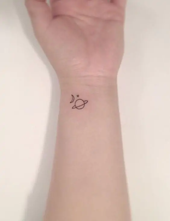 For those who love space and the cosmos, a tiny planet tattoo is a fun and quirky minimalist option. It can represent curiosity, exploration, and a connection to the universe. minimalist planet tattoo, small space tattoo ideas, simple planet tattoos