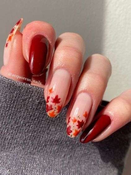 Burgundy nails with red and orange fall leaves accent.