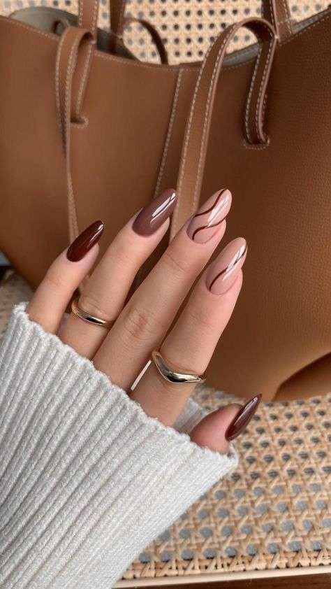 Nude and brown fall nails with swirl patterns.