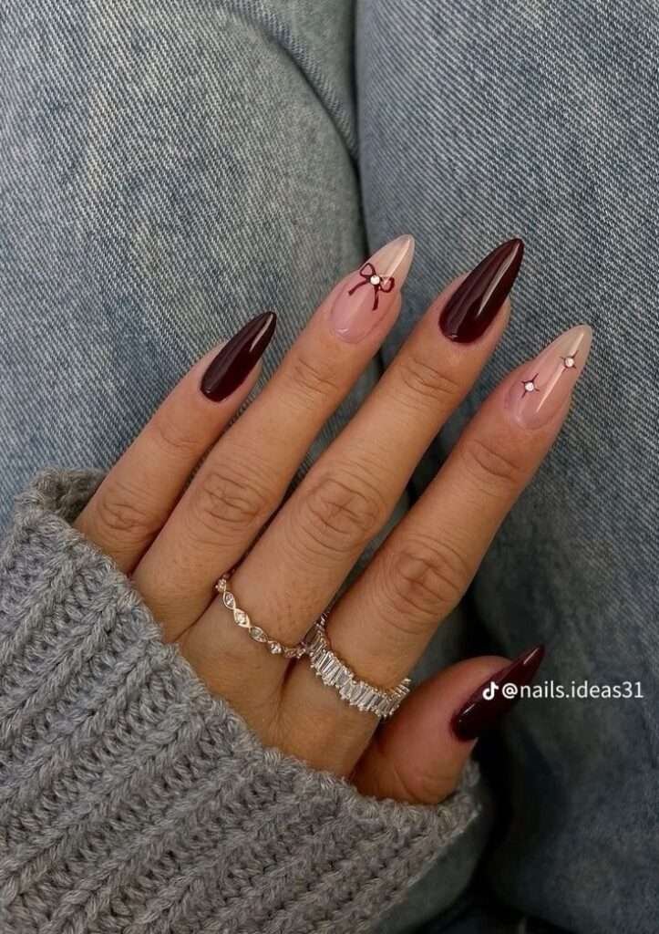 Burgundy and nude fall nails with bow accents.