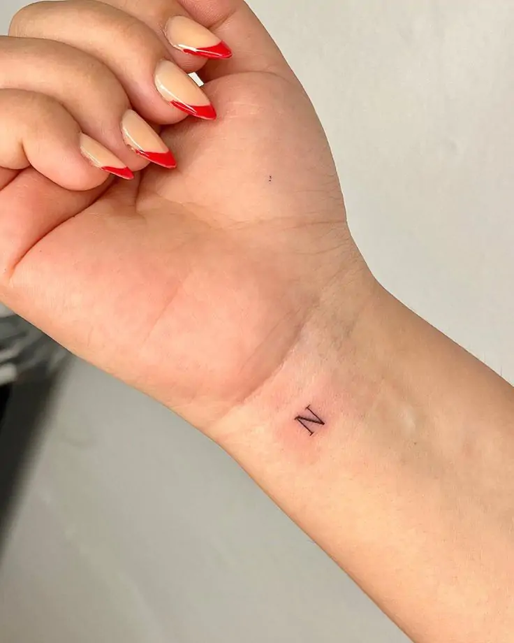 A tattoo with your initials, a loved one's initials, or a meaningful word is a subtle way to carry a personal connection. This design can be placed anywhere on the body and can be as small as you like. minimalist lettering tattoo, simple initials tattoo, tiny word tattoos