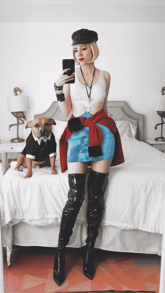 "Urban Chic Rebel Halloween costume ": White crop top, blue tie-dye mini skirt, black thigh-high boots, red jacket tied around the waist, black cap. People love Halloween costumes like this for their modern fashion and edgy style, blending self-expression and creativity. The bold look makes it a standout choice.