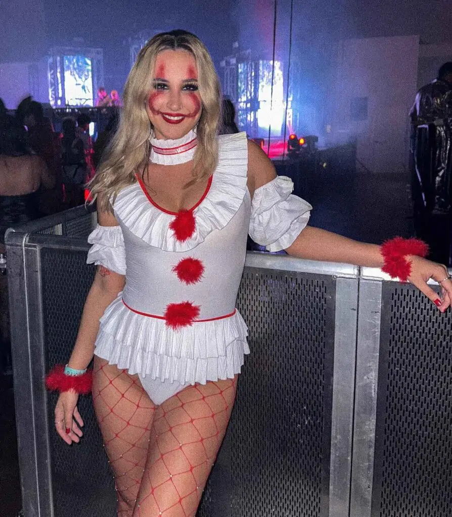Get ready for "The Candy Crusher Halloween Look"! This costume blends chunky denim overalls, a rainbow-striped shirt, and red thigh-high stockings, topped off with a faux axe.