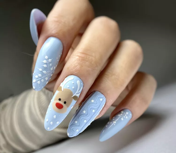 If the holidays are nearing, lean into the festivity by incorporating a cute, red-nosed reindeer on your nails. This beautiful wintry design features rudolph against a powder blue base and incorporates 3D snowflakes and sweater-inspired texture, too. 