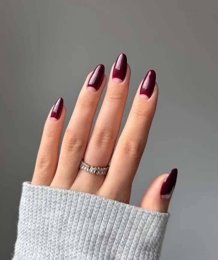 16. Simple Wine Red Winter Nails with Negative Space Cuticle Nail Art. Just picture these burgundy nails wrapped around a glass of red wine as you lounge next to the fireplace. Perfection!
