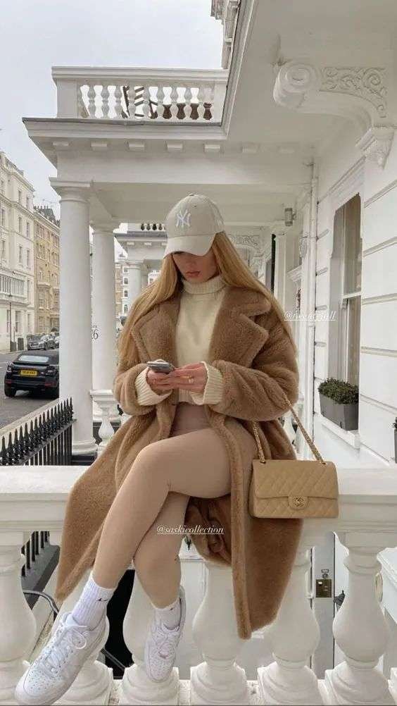 This outfit features a cozy, oversized camel teddy coat layered over a cream sweater and beige leggings. It’s a chic, neutral-toned winter look that blends warmth with effortless style.