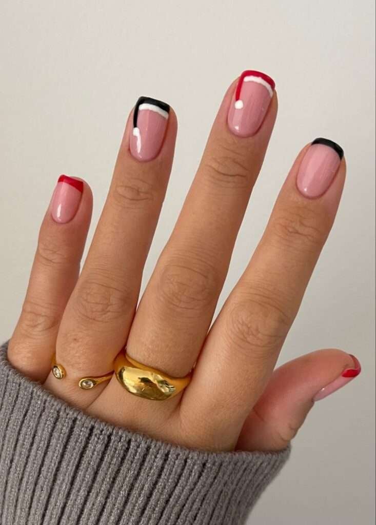 Imagine clean lines and bold color blocking against a soft, neutral backdrop. This manicure offers a fresh, minimalist take on holiday nail art. Each nail features a sheer, natural base, allowing the natural nail to peek through.