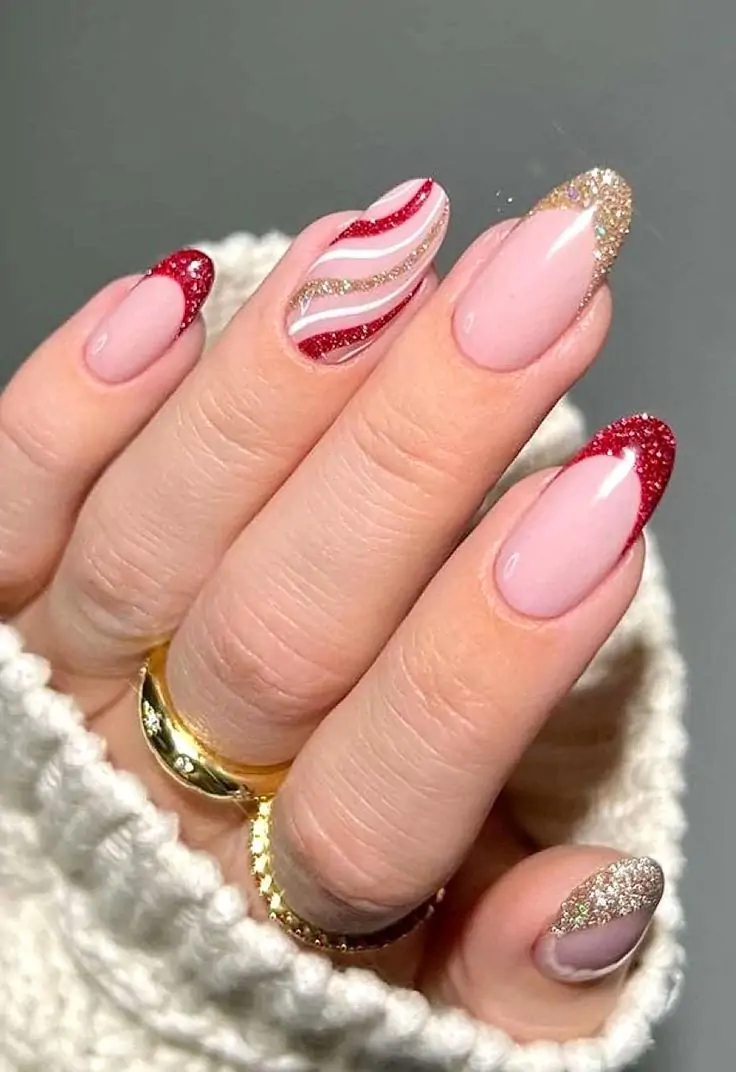 Light pink base with blue and silver glitter tips, one nail featuring a blue, silver, and white striped design. Perfectly paired with a silver ring and a cozy white knitted sweater for a complete winter look. Frosty and festive elegance at your fingertips!