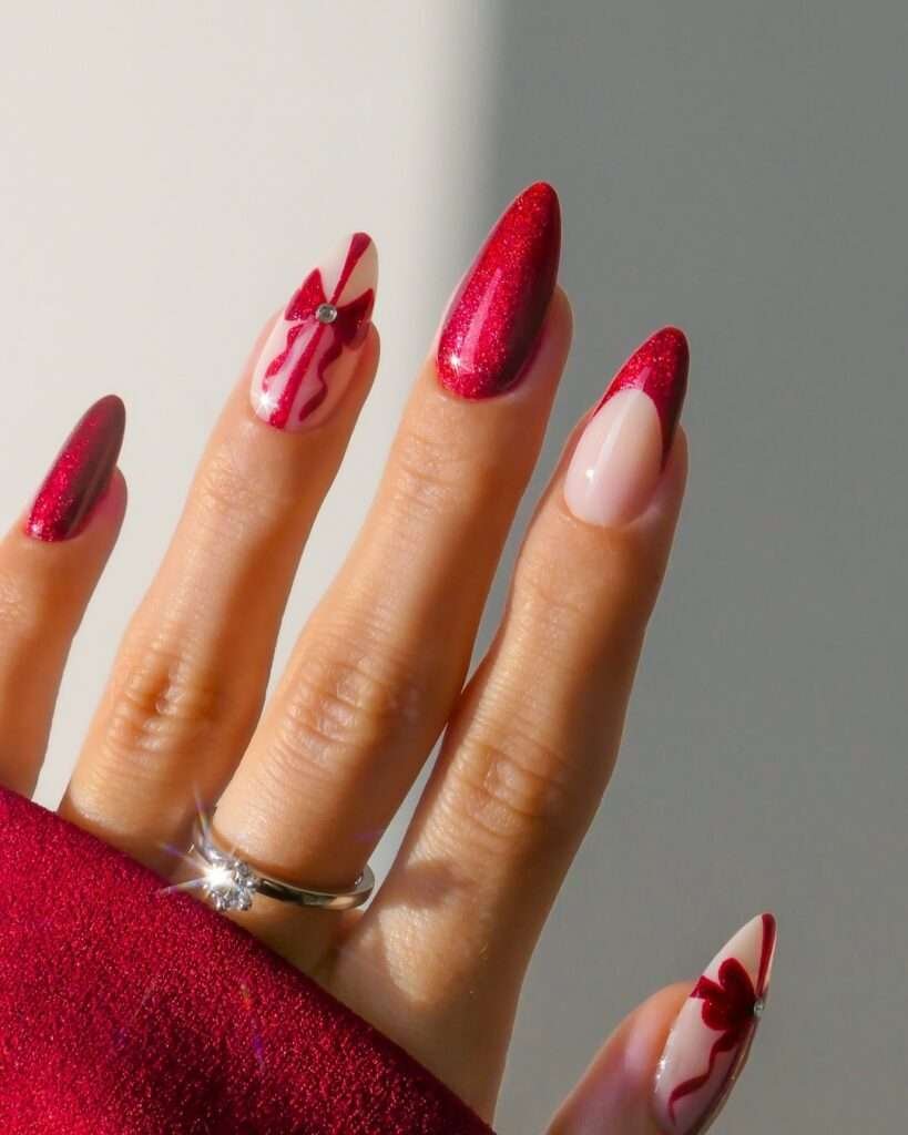 This festive manicure showcases a vibrant, glittery ruby red on some nails for a bold holiday statement.
Delicate, hand-painted red ribbons adorn a few nails, adding a touch of whimsical charm.
A subtle sparkle at the ribbon's center mimics a tiny diamond accent, completing this elegant Christmas design.