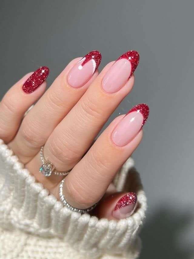 The nails have a sheer, natural base, maintaining a clean and sophisticated look. The tips are coated in a rich, shimmering crimson glitter, like sparkling ruby dust. This creates a striking contrast against the natural nail and instantly adds a touch of holiday glamour. This design is perfect for those who appreciate classic elegance with a festive flair. It's a versatile look that can be dressed up or down, making it suitable for any holiday occasion.