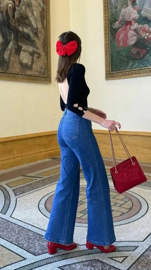 Capture the essence of spring with a stylish black top paired with blue high-waisted jeans. Add a pop of color with red shoes and a chic red handbag, and top it off with a large red bow for a playful touch. Perfect for a casual stroll through an art gallery or museum.