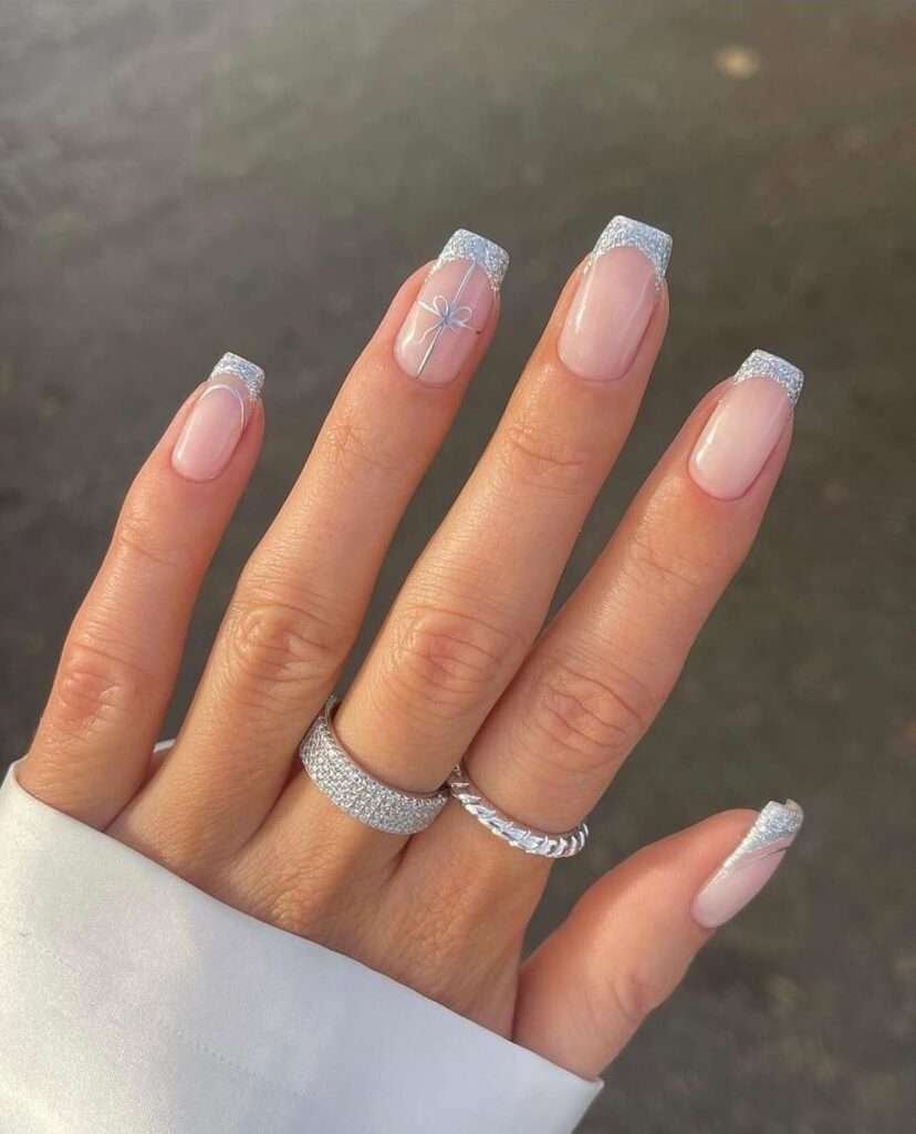 Capturing the magic of winter and the joy of the holiday season in a subtle and sophisticated way. Each nail has a sheer, natural base, creating a clean and understated look. This manicure evokes the delicate beauty of a winter frost, combined with the festive feeling of perfectly wrapped presents.