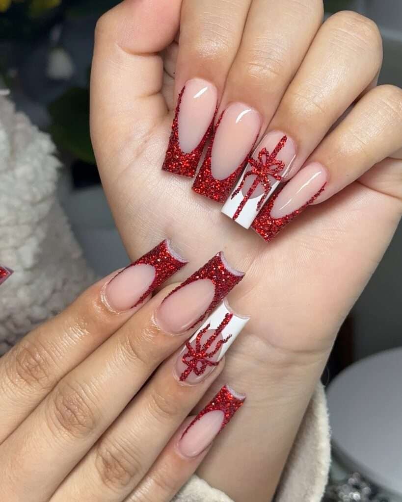 The contrast between the clean lines and the dazzling glitter creates a truly festive and glamorous holiday look. This eye-catching manicure features a striking combination of a classic French tip with a festive twist: a chunky red glitter. Some nails showcase a solid white base adorned with delicate red ribbon designs, resembling beautifully wrapped gifts.