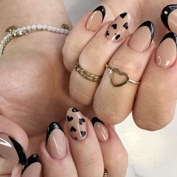 This Valentine's Day manicure reimagines the French tip with a bold black line and a sprinkling of tiny black hearts. The result is a stylish and playful look that's perfect for the occasion.