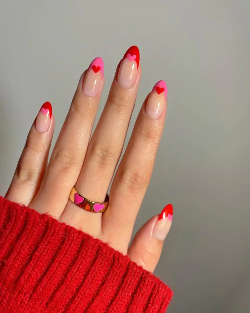 These nails are totally giving me Valentine's Day vibes! The red tips peeking out from under the pink hearts are SO cute. It's like a little surprise with every move of my hand! I can totally imagine myself twirling my fingers and showing these off to everyone.