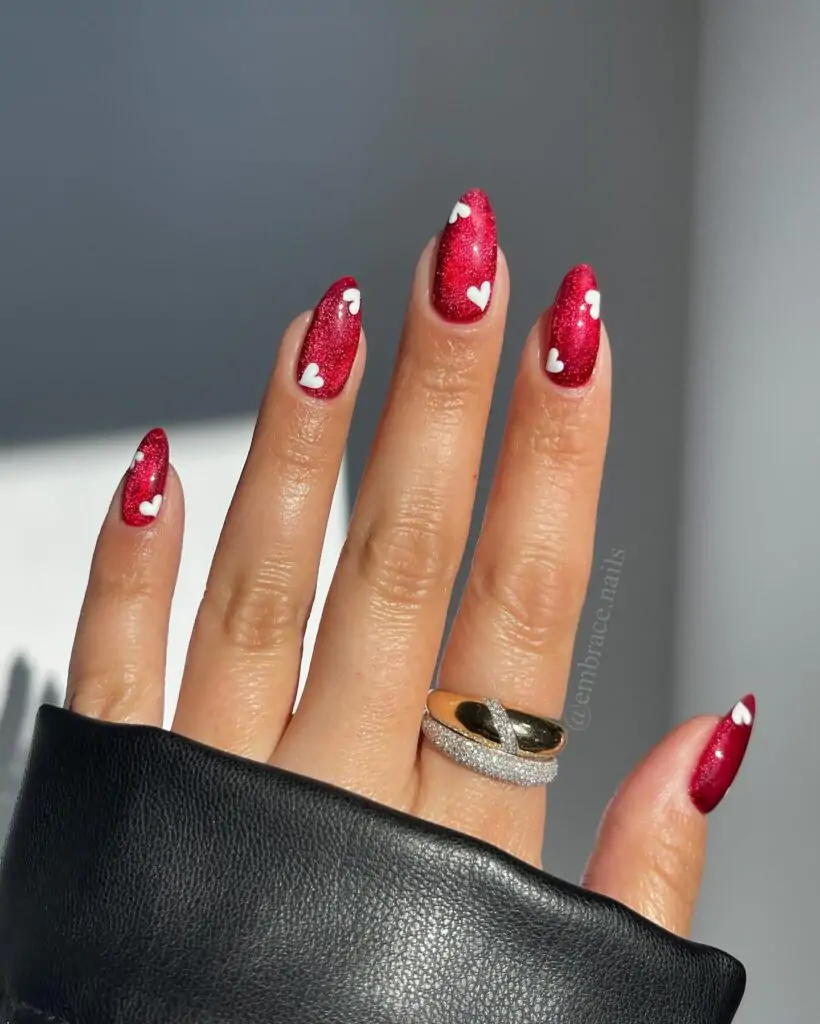 These nails are so festive! The deep red is perfect for Valentine's Day, and the little white hearts add a touch of whimsy. It's a simple design, but it's so effective! I love how the hearts pop against the rich color."