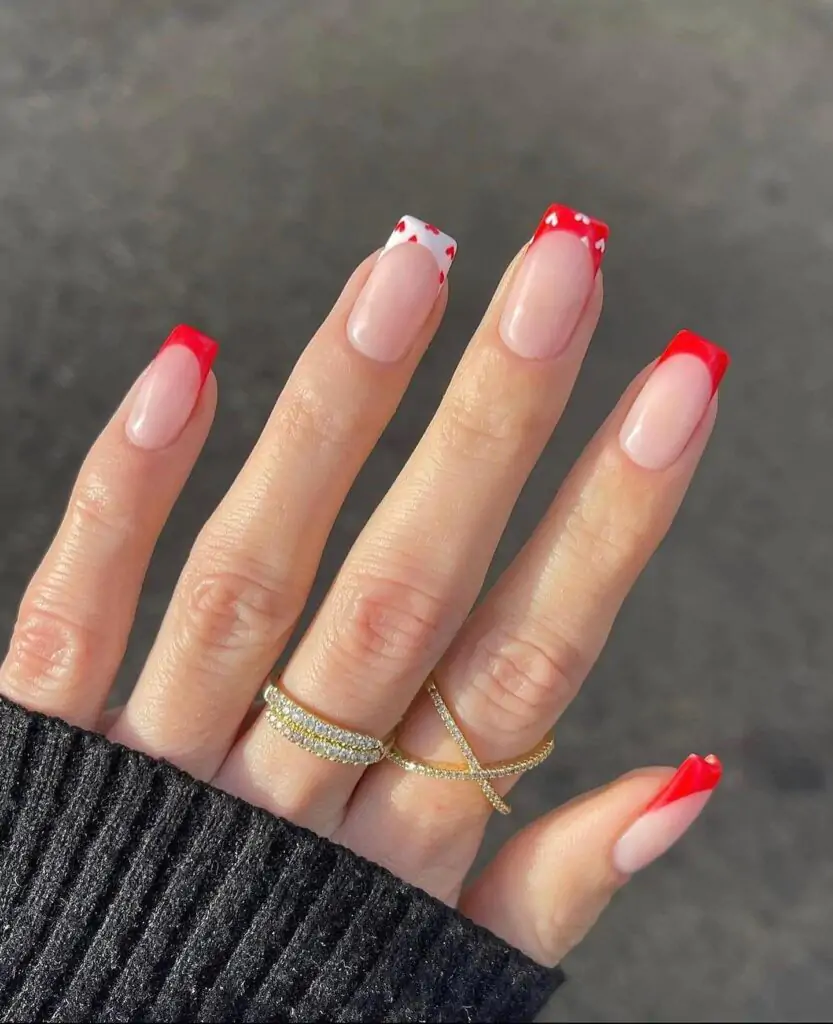 Okay, I'm obsessed! This is like a classic French manicure, but with a fun twist. The red tips are so bold, and those little white hearts are just the cutest! It's a perfect way to add a touch of Valentine's Day cheer to your look.