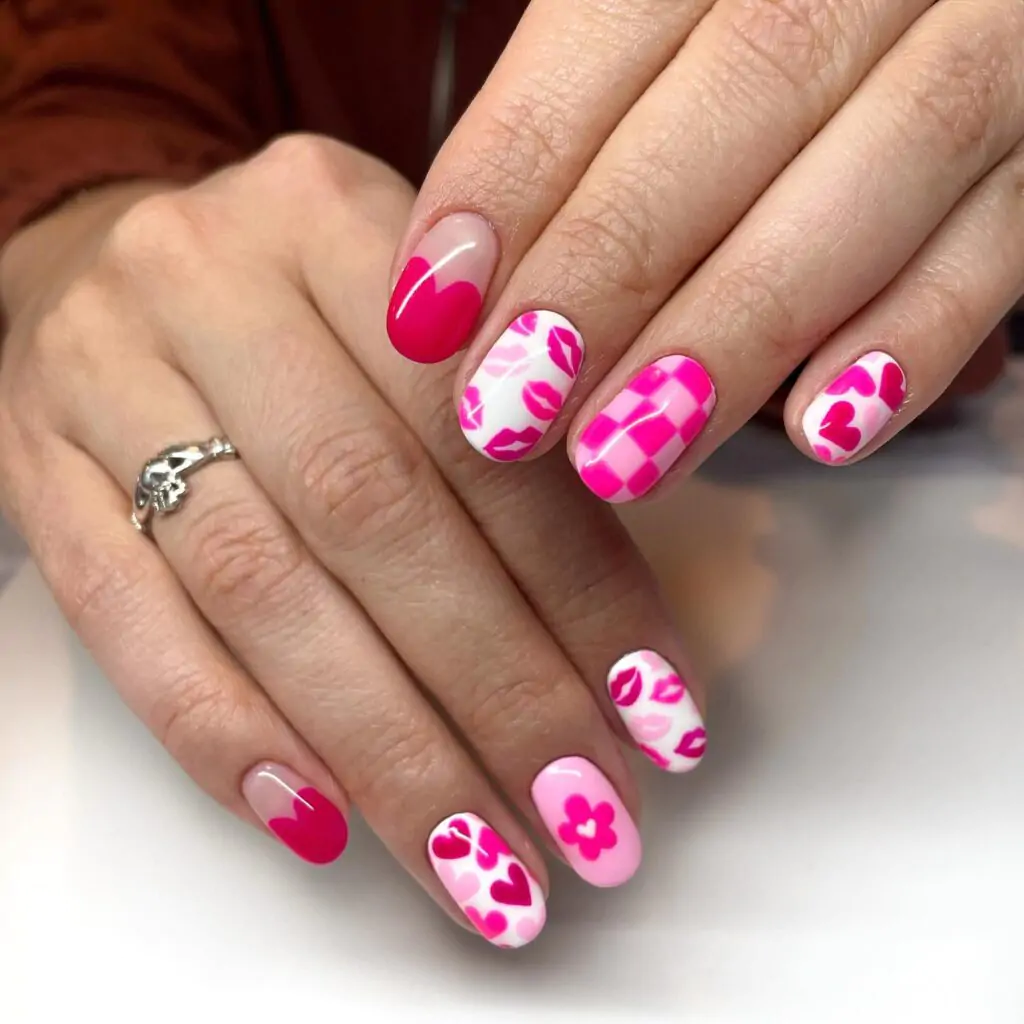 This playful Valentine’s Day manicure is a love letter to all things cute! Each nail is a canvas for a different adorable design, from heart-shaped French tips to playful pink checkerboards and even adorable little kisses. It's a whimsical and romantic look that's sure to turn heads.