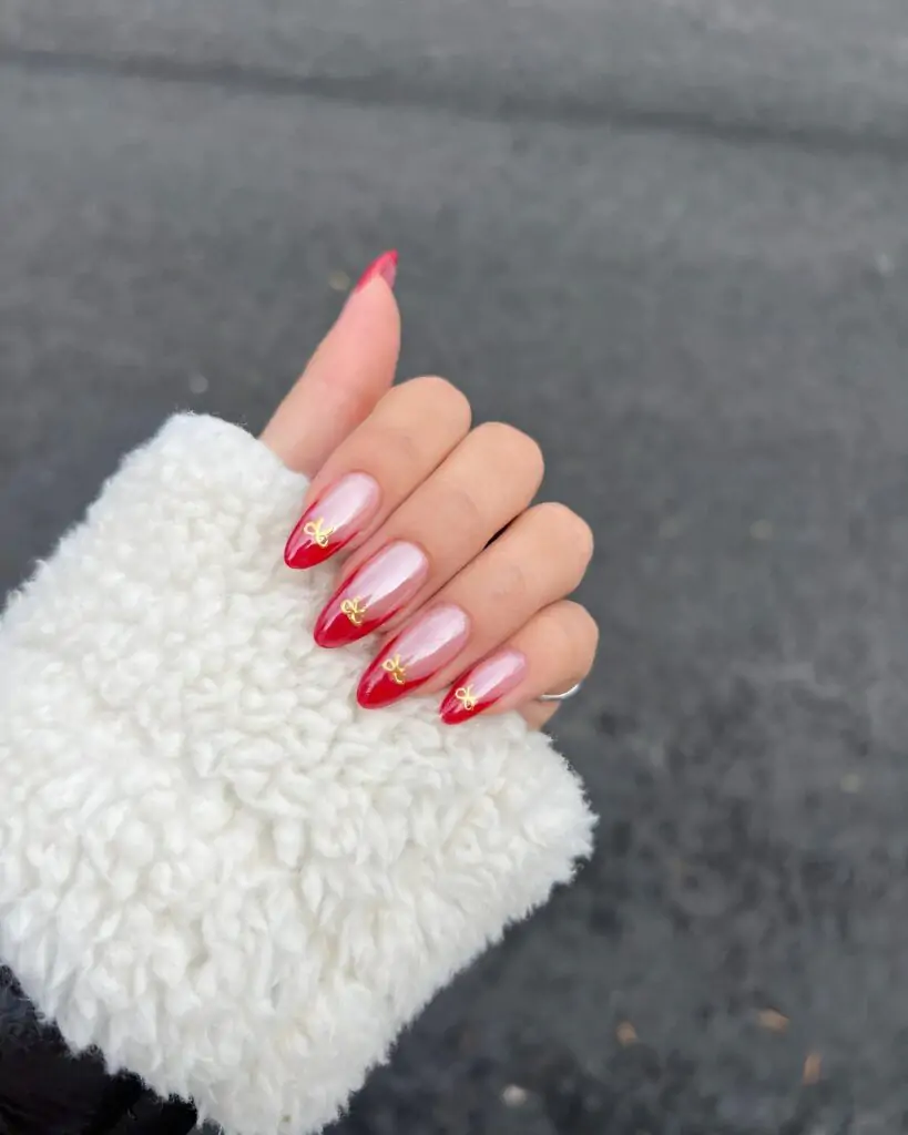 Get ready to steal the show with this flirty French manicure! Each almond-shaped nail is adorned with a gradient of red and a delicate gold bow, adding a touch of whimsical charm. This design is perfect for the fashionista who loves to make a statement.