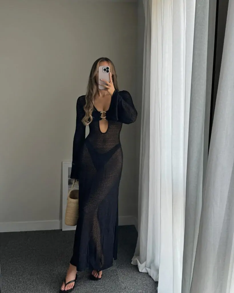 Capture the essence of minimalist sophistication with Noir Elegance—a stunning black, sheer long-sleeve dress featuring a keyhole cutout and paired with chic black flip-flops. Accessorize with a woven basket bag for an effortlessly stylish indoor look.