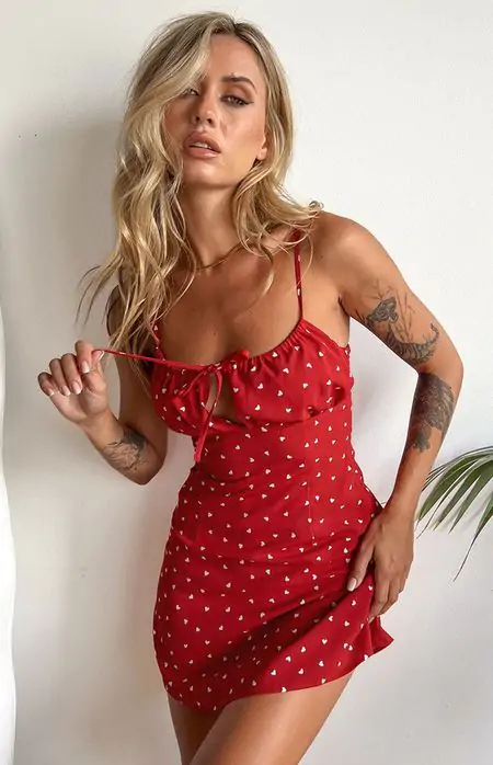 The red mini dress with thin straps and a tie-front detail, decorated with charming white heart prints, makes this a perfect Valentine's Day outfit idea. It's playful yet sophisticated—ideal for making a lasting impression!