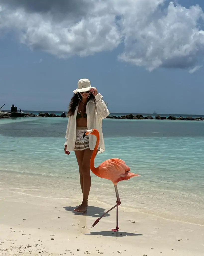 This chic beach ensemble, featuring a white oversized shirt, stylish bikini, and crochet shorts paired with a bucket hat, offers a perfect blend of comfort and sophistication for a seaside adventure.