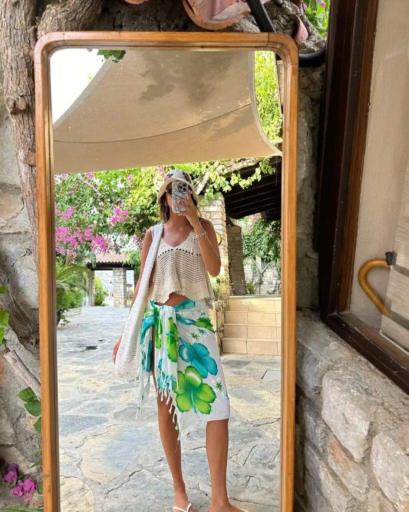 Feel the essence of summer with the 'Tropical Breeze' look: a chic crochet crop top paired with a vibrant floral sarong, accessorized with a sun hat and a woven bag, perfect for a stylish beach day.