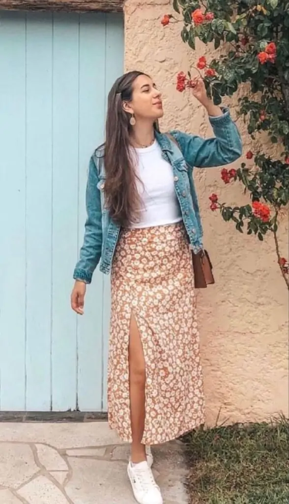 A floral midi skirt paired with a fitted denim jacket and white sandals. Accessorize with a floppy hat and simple jewelry. Why It Works: A mix of relaxed and feminine, this outfit is perfect for everything from a day trip to a casual outdoor gathering. The floral skirt screams spring, while the denim jacket gives it a cool edge.