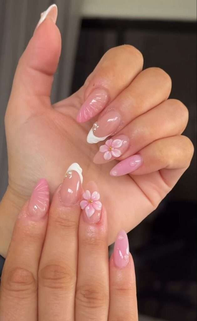 This vibrant nail art style is most commonly referred to as 3D Tropical Shell and Floral nails. The specific design featured in your image is often titled "Summer Wonder" by some nail artists and retailers. 3D Seashells: Textured, raised ridges that mimic the look of real shells, often accented with pearls. Tropical Florals: Hand-painted or 3D flowers, typically hibiscus or other island-inspired blooms in bright pinks, oranges, and yellows. Aura & Gradients: Soft, blended color backgrounds that create a "sunset" or "tropical" glow. Oceanic Accents: Small details like starfish, gold studs, and water droplets (using clear builder gel).