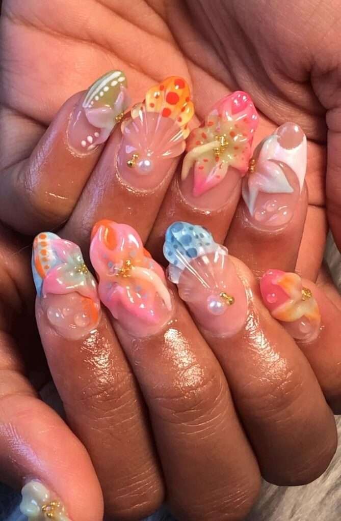 This vibrant nail art style is most commonly referred to as 3D Tropical Shell and Floral nails. The specific design featured in your image is often titled "Summer Wonder" by some nail artists and retailers. 3D Seashells: Textured, raised ridges that mimic the look of real shells, often accented with pearls. Tropical Florals: Hand-painted or 3D flowers, typically hibiscus or other island-inspired blooms in bright pinks, oranges, and yellows. Aura & Gradients: Soft, blended color backgrounds that create a "sunset" or "tropical" glow. Oceanic Accents: Small details like starfish, gold studs, and water droplets (using clear builder gel).