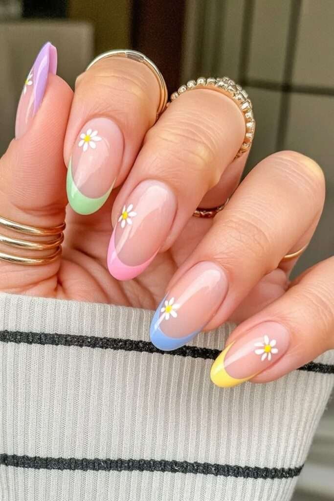 This vibrant and playful look is most commonly referred to as Pastel Rainbow French Tip nails with Floral Accents. n the 2026 nail scene, this specific aesthetic is also called "Skittle French" or "Cottagecore French" because it mixes different colors on each finger with dainty, nature-inspired details.