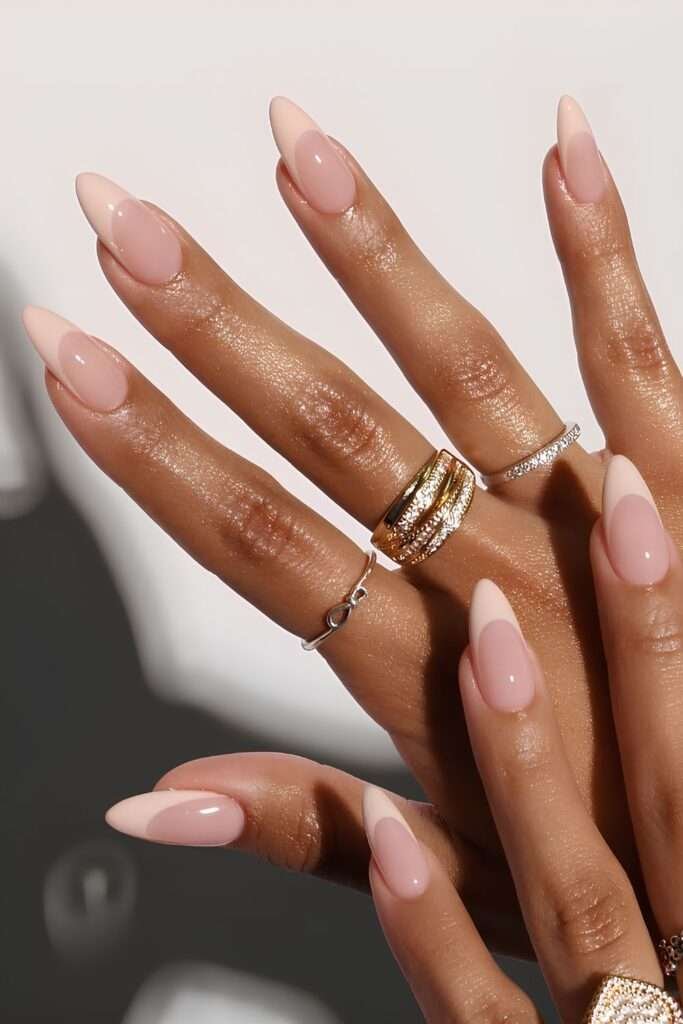 This sophisticated look is widely known as a Peach French Tip Manicure on an Almond shape. In 2026, this specific minimalist style is often called "American French" or "Vanilla Nails" when the contrast between the base and tip is soft and natural rather than stark white.