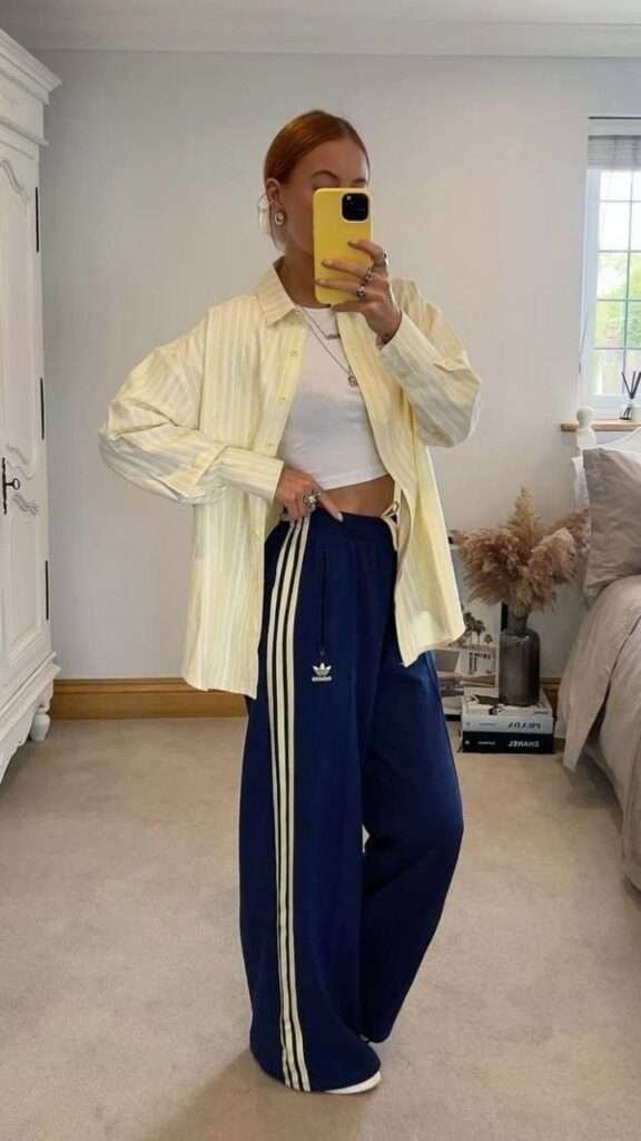 What started with the Adidas track pants trend has evolved into a full aesthetic philosophy. Saint Laurent's Spring 2026 campaign crystallized it: windbreakers in '80s-inspired colors styled with lace-trimmed shorts and stiletto pumps. Track jackets with silk slip skirts. Retro anoraks worn over bias-cut midi dresses. The athletic silhouette, broken free from its sporting context.