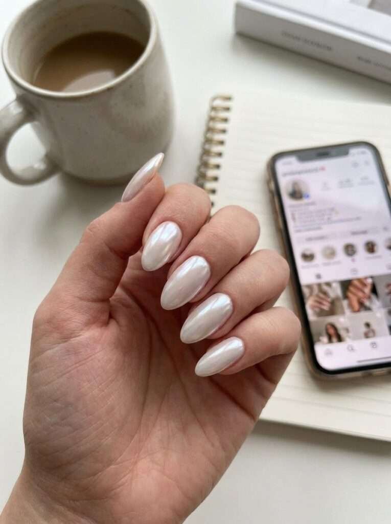 Glazed donut chrome nails are the viral, translucent-pearl manicure trend that prioritizes a "lit-from-within" glow over opaque color. This look features a sheer base—typically a milky white or pale pink—finished with a specific pearl chrome powder that mimics the shiny, sugary glaze of a Krispy Kreme donut.